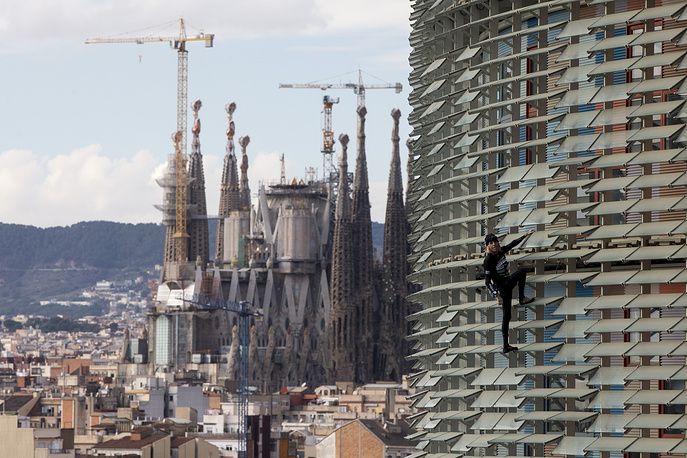 Скалолаз Ален Робер без страховки взобрался на небоскреб в Барселоне