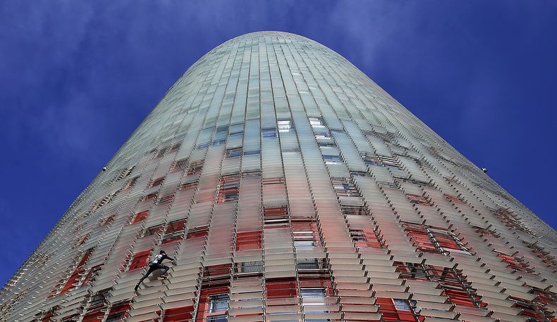 Скалолаз Ален Робер без страховки взобрался на небоскреб в Барселоне