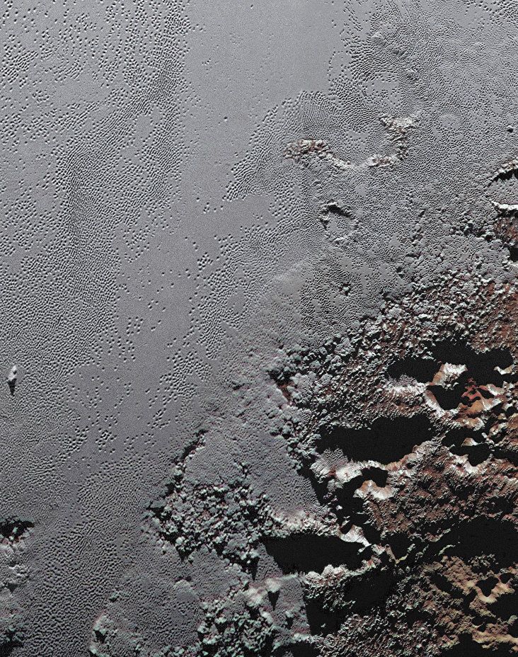 NASA показало горы и долины Плутона в цвете